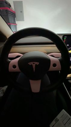 the interior of a tesla car is shown with pink trims and black steering wheel