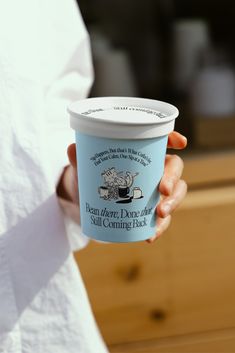 a person holding a cup of coffee in their hand