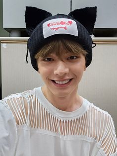 a young man wearing a black hat with ears