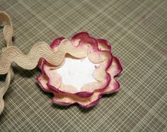 a pink flower sitting on top of a table next to a pair of tape cutters