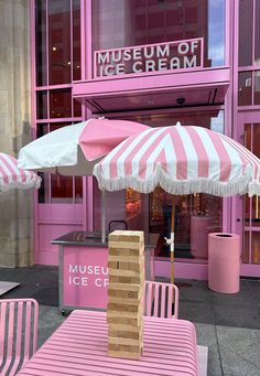 pink and white striped umbrellas in front of a museum ice cream shop