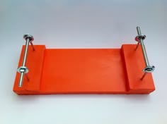 an orange piece of wood with two metal handles