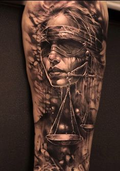 a man's leg with an image of a woman holding a scale on it