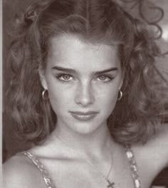 a black and white photo of a woman with her hair in half - up style