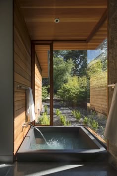 an outdoor jacuzzi tub in the middle of a room with wooden walls and flooring