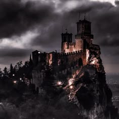 an old castle on top of a hill with dark clouds in the sky above it
