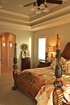 a bedroom with a large bed and ceiling fan