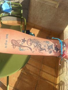 a person's arm with tattoos on it and some chairs in the back ground
