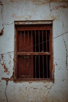 an old window with bars on the side of it