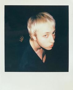 a polaroid photograph of a young man with blonde hair
