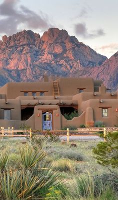 an adobe style house with mountains in the background