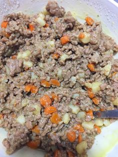 a white plate topped with meat and veggies next to a knife on top of a table