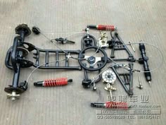 the front suspensions and parts of a car are laid out on the ground in preparation for repair