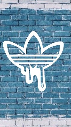 a blue brick wall with white paint dripping from the bottom to the bottom, and an image of a plant on top