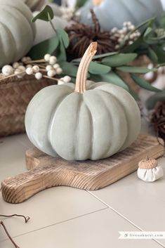 a white pumpkin sitting on top of a wooden board