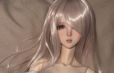 an animated image of a woman with long blonde hair and blue eyes, wearing a white dress