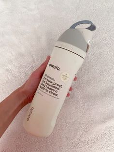 a hand holding a bottle of water on top of a towel