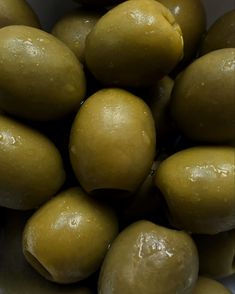 a pile of green olives sitting on top of each other