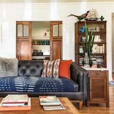 a living room filled with furniture and lots of books on top of a hard wood floor