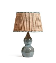 a lamp that is sitting on top of a table next to a light fixture with a brown shade