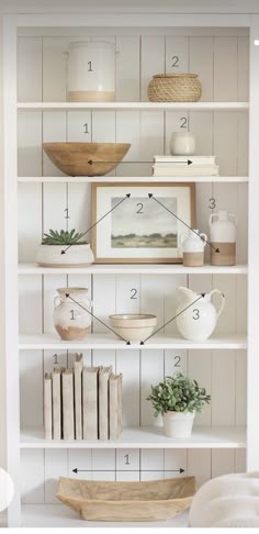 a white book shelf filled with books and vases