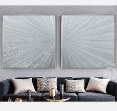 two paintings on the wall above a couch in a living room with pillows and coffee table