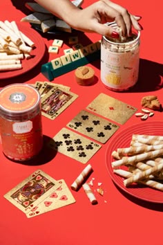 a red table topped with lots of different types of cookies and crackers on top of it