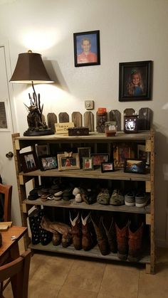 a shelf with many pairs of shoes on it in a living room next to a lamp