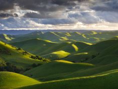 the rolling hills are covered in green grass