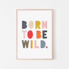 a framed print with the words born to be wild in multicolors on it