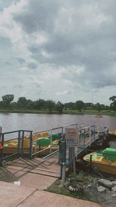 there are many small boats tied to the dock at the water's edge,
