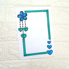a card with blue hearts hanging from it's side on a white tile wall