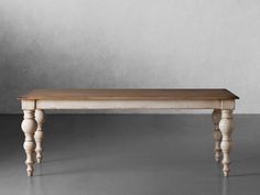 a wooden table with two legs and a wood top on a gray floor in front of a wall