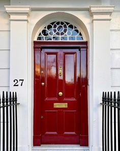 a red front door with black iron fence around it