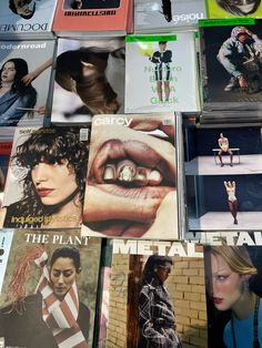 many magazines are stacked on top of each other with one woman's face in the middle