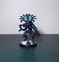 a toy figurine is displayed on a table with white walls in the background