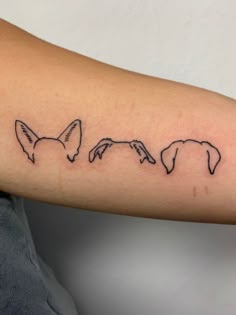a woman's arm with an outline of three dogs on the left side of her arm