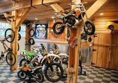 several dirt bikes are on display in a garage
