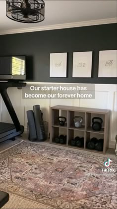 a gym room with a treadmill, exercise equipment and pictures on the wall above it