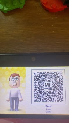 a close up of a cell phone with a qr code on the screen and legos in the background