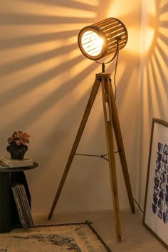 a wooden tripod floor lamp sitting on top of a rug