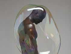 a sculpture of a man in a glass bowl