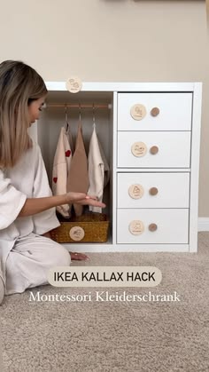 a woman sitting on the floor in front of a dresser