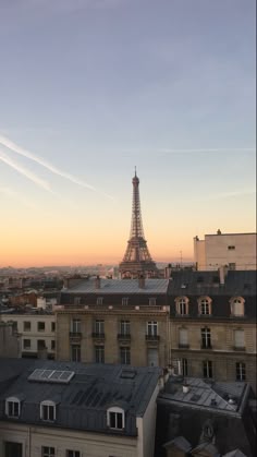the eiffel tower towering over paris in the distance is seen from an apartment building