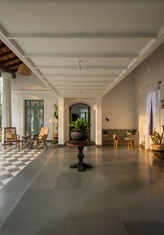 a large room with a checkered floor and potted plant in the center on a pedestal