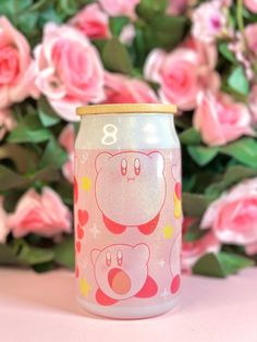 a pink and white can with two bears on it next to some pink roses in the background