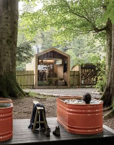 an outdoor hot tub in the middle of a wooded area with two people sitting inside it