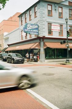 a blurry photo of cars driving down the street in front of a storefront