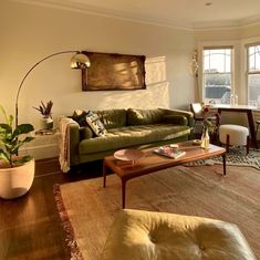 a living room filled with furniture and a large window covered in sun shining through the windows