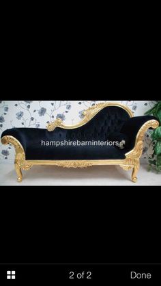 a black and gold couch sitting on top of a table
